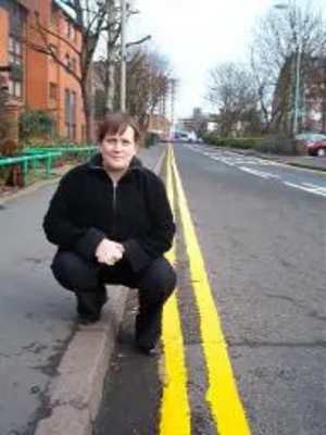 Debbie Almey next to the newly painted double yellow lines on Jarrom Street.